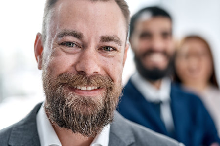 A leader must inspire or his team will expire. Portrait of a businessman standing in an office with his colleagues in the background.の写真素材