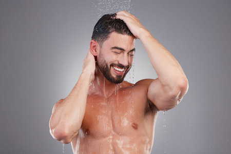Shower, keratin and cleaning hair with a man in studio on a gray background for hygiene or grooming....