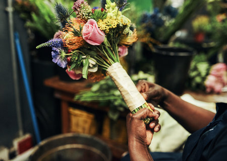 Flowers are natures gifts to us. an unrecognizable florist wrapping up a bouquet of flowers inside a plant nursery.の写真素材