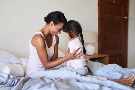 Nothing comes close to you in this world. a beautiful young mother bonding with her little girl in bed at home.の写真素材