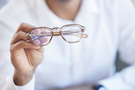 Glasses, optometry and hand of optometrist holding spectacles, eyewear or specs for ophthalmology in...