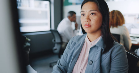 Business, asian woman and focus on typing, computer and online schedule in modern office. African American female, administrator and employee with concentration, corporate planning and professionalの写真素材