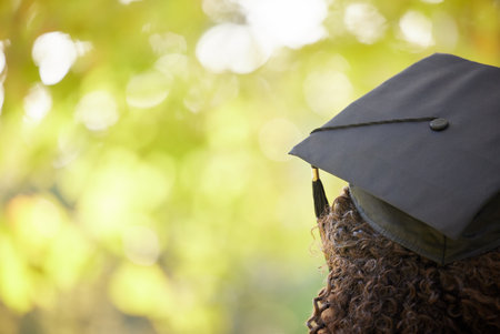 Graduation cap, trees and back of woman outdoor for education achievement, success and goals with bokeh. Nature, mockup space and female university or college graduate planning future for motivation.の写真素材