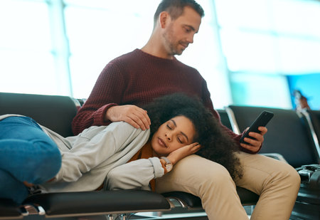 Airport, woman sleep and couple waiting for airplane for holiday travel together.Tired, flight delay and luggage of man on phone and chair for a international vacation journey and global transportの写真素材