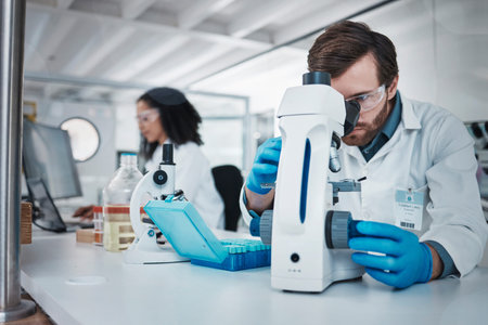 Man, doctor and forensic scientist with microscope for examination, experiment or test at...
