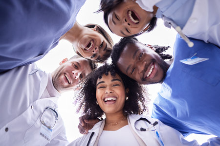 Doctor, group portrait and below circle for motivation, support and collaboration with smile, solidarity and diversity. Friends, doctors and face with teamwork, goals and help in healthcare at clinicの写真素材