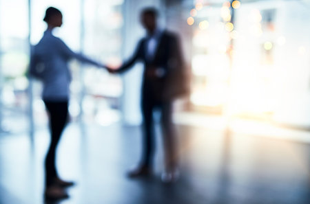 Meet with people who make great things happen. Defocused shot of two businesspeople shaking hands in an office.の写真素材