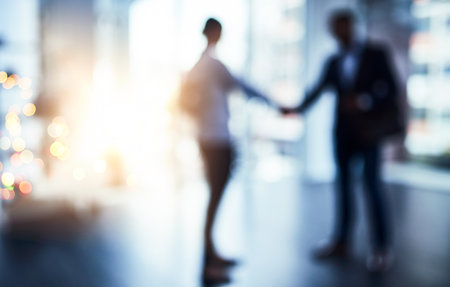 Together we can achieve so much more. Defocused shot of two businesspeople shaking hands in an office.の写真素材