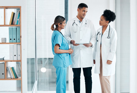 Doctors, nurse and tablet for healthcare team planning care, discussion or meeting about medical research. Women and man with app talking for communication, online consultation and advice in hospitalの写真素材
