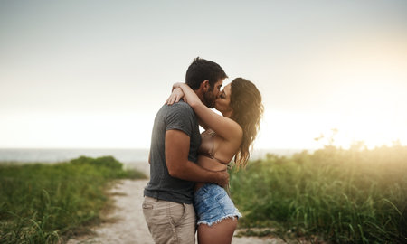 One kiss says it all. a young couple spending a romantic day at the beach.の写真素材