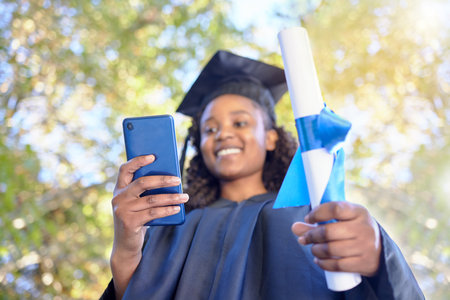 College graduation, phone and black woman with certificate in hand to celebrate and share achievement. University student happy for goals, success and education diploma while online for social mediaの写真素材
