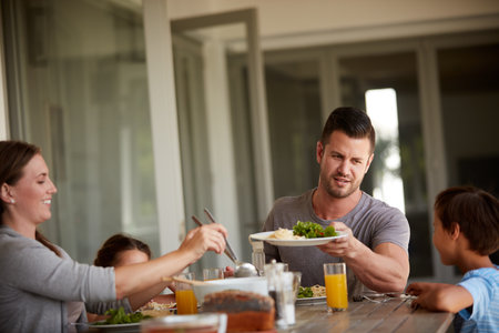 Sitting down for a wholesome meal. a family of four sitting down for a meal at home.の写真素材