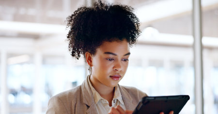 Business woman, tablet and face with focus and leadership, technology and corporate communication. Email, networking and digital marketing with seo, black woman executive typing with research onlineの写真素材