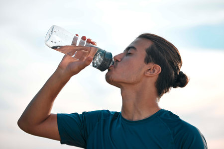 Fitness, drinking water and man with training, exercise and workout for balance, healthy lifestyle...