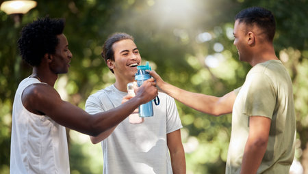 Fitness, water bottle and friends toast in nature after workout, exercise or training. Sports, comic and group of happy men cheers with liquid to celebrate goals, targets and laughing at funny joke.の写真素材