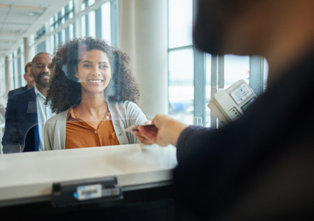 Black woman, ticket check and airport counter with a paper for travel or box office service. Happy customer person at consultant booth window for passport, work booking and buying pass at sellerの写真素材