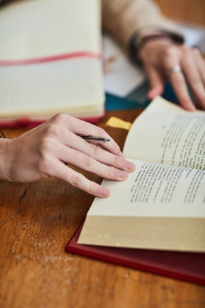 Paging through notes for her next class. Closeup shot of an unidentifiable university student doing...