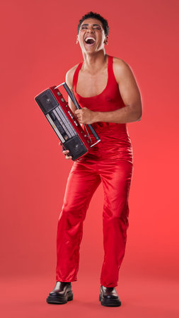 Radio, laughing and red background with a gen z man in studio listening to music for carefree fun....