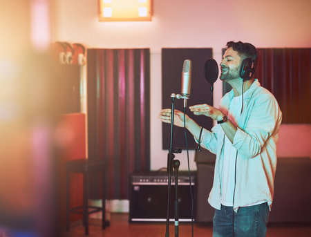Musician, microphone or singing in studio for album recording, theatre night performance or radio industry. Man, singer or artist with headphones for production, theater melody or jazz karaoke mediaの写真素材