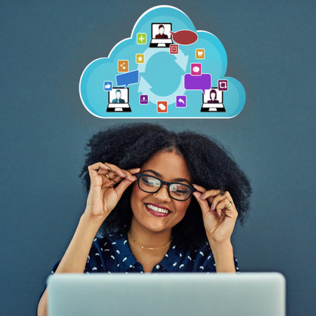 Were all connected thanks to wireless technology. Studio shot of a young woman using a laptop with a cloud illustration above her against a gray background.の写真素材