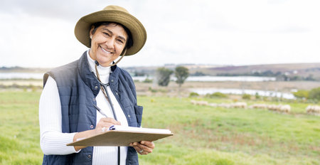 Clipboard, farmer and portrait of a woman on a farm with checklist to monitor growth and development. Happy, smile and mature female working on sustainable, agriculture and agro field in countryside.の写真素材