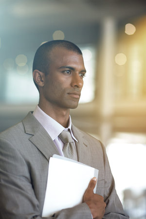 Focused and ready for business. a businessman carrying paperwork.