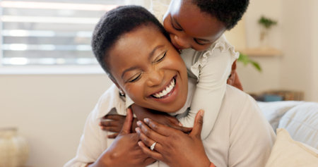 Love, mother and excited child hug playing together bonding in bedroom at house. Happy black woman and baby affection smile, trust and support care or enjoy spending quality time at family homeの写真素材