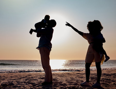 Sunset silhouette, beach and family play, bond or enjoy quality time together for vacation love, holiday peace or freedom. Ocean sea water, nature travel shadow or fun nature people in Toronto Canadaの写真素材