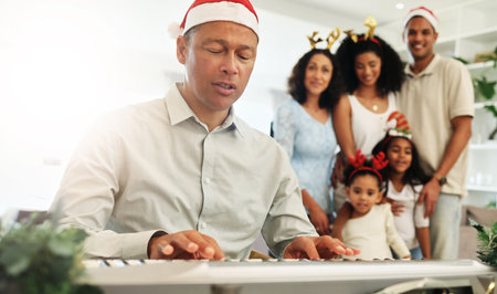 Man, christmas singing and piano for happy family, festive celebration or bonding for love. Father, teaching and music at keyboard for development, education or holiday spirit with mom, kids and homeの写真素材