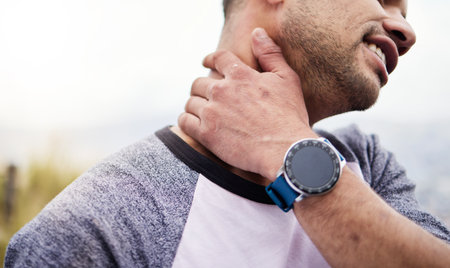Fitness, neck pain and man athlete with a smartwatch for exercise time outdoor. Workout, running injury and joint problem with sport accident from training during competition with muscle strainの写真素材