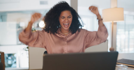 Celebration, happy and business woman in the office reading good news for job promotion on her laptop. Winner, happiness and professional female employee celebrate success in the workplace in Mexico.の写真素材