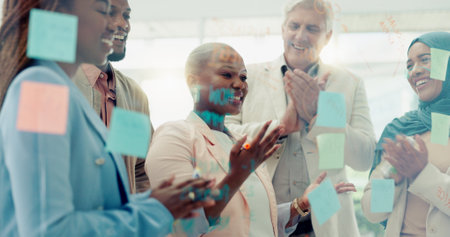 Meeting, planning and sticky notes on glass in the office with a diversity business team planning strategy. Teamwork, collaboration and coaching with a black woman leader teaching her staff at workの写真素材