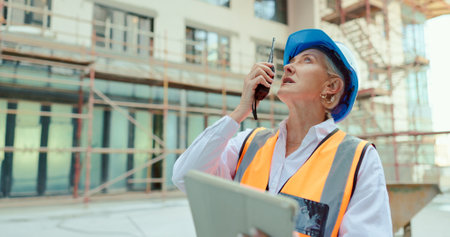 Construction worker, call or architect woman with tablet for networking, communication or planning in construction site. Logistics, industrial or employee with leadership for engineering strategyの写真素材