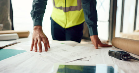Hands of architect check blueprint at construction site for building, house or real estate industrial development. Architecture industry man, engineer and contractor inspection of project design planの写真素材