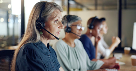 Call center, customer support and telemarketing with a senior woman at work as a consultant in her office. Crm, contact us and sales with a mature female consulting using a wireless headset at workの写真素材