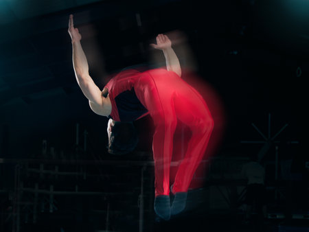 Sports, gymnastics and jump with man in stadium for fitness, speed and motion blur. Workout, action and challenge with flexible athlete training in gym arena for performance, exercise and healthの写真素材