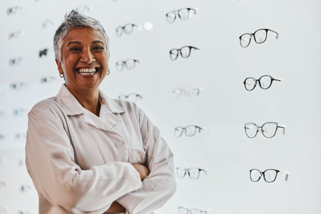 Portrait, woman and smile of optician with arms crossed in shop or store for glasses, eyewear or spectacles. Ophthalmology, vision and laughing, proud and confident senior female medical optometrist.の写真素材