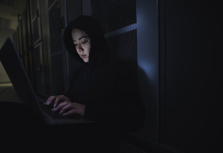 Hacking, server room and woman computer coding, data center crime and ransomware of cyberpunk in dark. Laptop hacker, person or thief in cybersecurity, information technology and criminal programmerの写真素材