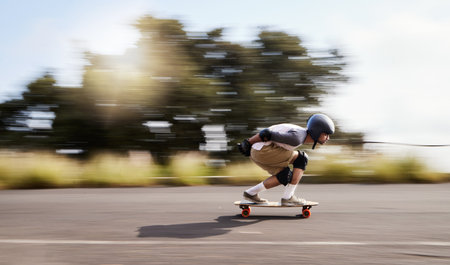Skateboard, motion blur and mountain with man in road for speed, freedom and summer break. Sports, adventure and wellness with guy skating fast in street for training, gen z and balance in natureの写真素材