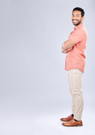 Portrait, mock up and a man in studio, arms crossed standing on a gray background for branding or product placement. Marketing, advertising and mockup with a handsome young male posing on blank spaceの写真素材