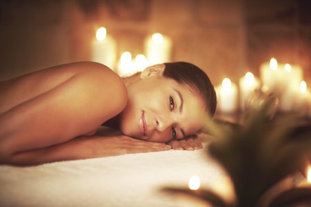 Massage day is my favorite day of the week. Closeup shot of a young woman relaxing during a spa treatment.の写真素材