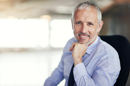Work smarter, not harder. Cropped portrait of a mature businessman sitting in his office.の写真素材