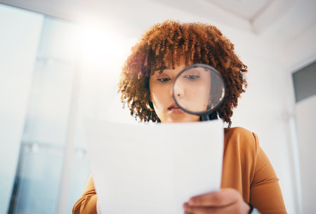 Black woman, magnifying glass and office for search at documents, hr expert or focus for recruitment. Human resources, manager and paper inspection for hiring, opportunity and job for future employeeの写真素材