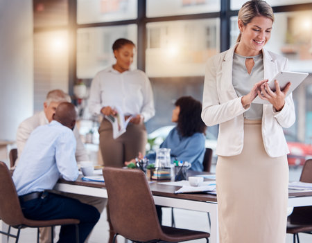 Business woman, tablet and meeting for digital marketing, schedule planning or management at office. Happy female with smile in market research, idea or project plan on touchscreen at team conferenceの写真素材