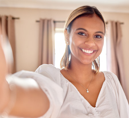 Woman, portrait smile and selfie for profile picture, vlog or social media post at home. Happy friendly beauty female influencer or vlogger face smiling in POV for photo, memory or happiness onlineの写真素材