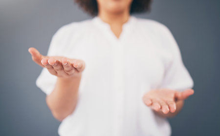 Woman, hands and space for choice in studio for product placement, palm and mockup or decision. Model person with hand for advertising promotion deal and brand offer or balance scale gray backgroundの写真素材
