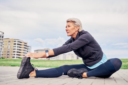 Woman, stretching exercise and sports on sky mockup, park ground and training motivation in Miami. Senior female warm up legs outdoor for workout, fitness and thinking of healthy mindset, body or runの写真素材