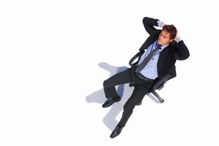 Top view of a relaxed business man sitting on a chair. Top view of a relaxed young business man sitting isolated on a chair on white.の写真素材