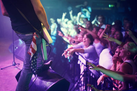 Guitar, concert and crowd at music festival, stage performance party, dance or celebration youth lifestyle. Audience, group of people or fans celebrate and star, musician or artist in disco nightclubの写真素材