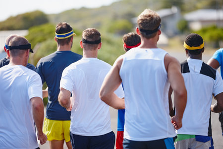 Band of brothers on the run. Rearview shot of a group of men running a marathon.の写真素材